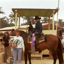 Marian Molthan, MD, of Foxglove Farm, holds one of Spring Ledge Irish Whiskey's championship trophies while standing next to Whiskers and rider Kathy McCarthy at the 1986 West Coast Connemara Show in Ventura, California. Whiskers competed in hunters, Western and driving classes.