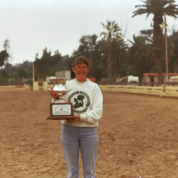 Marian Molthan, MD, of Foxglove Farm, holds one of Spring Ledge Irish Whiskey's championship trophies at the 1986 West Coast Connemara Show in Ventura, California. Whiskers competed in hunters, Western and driving classes.